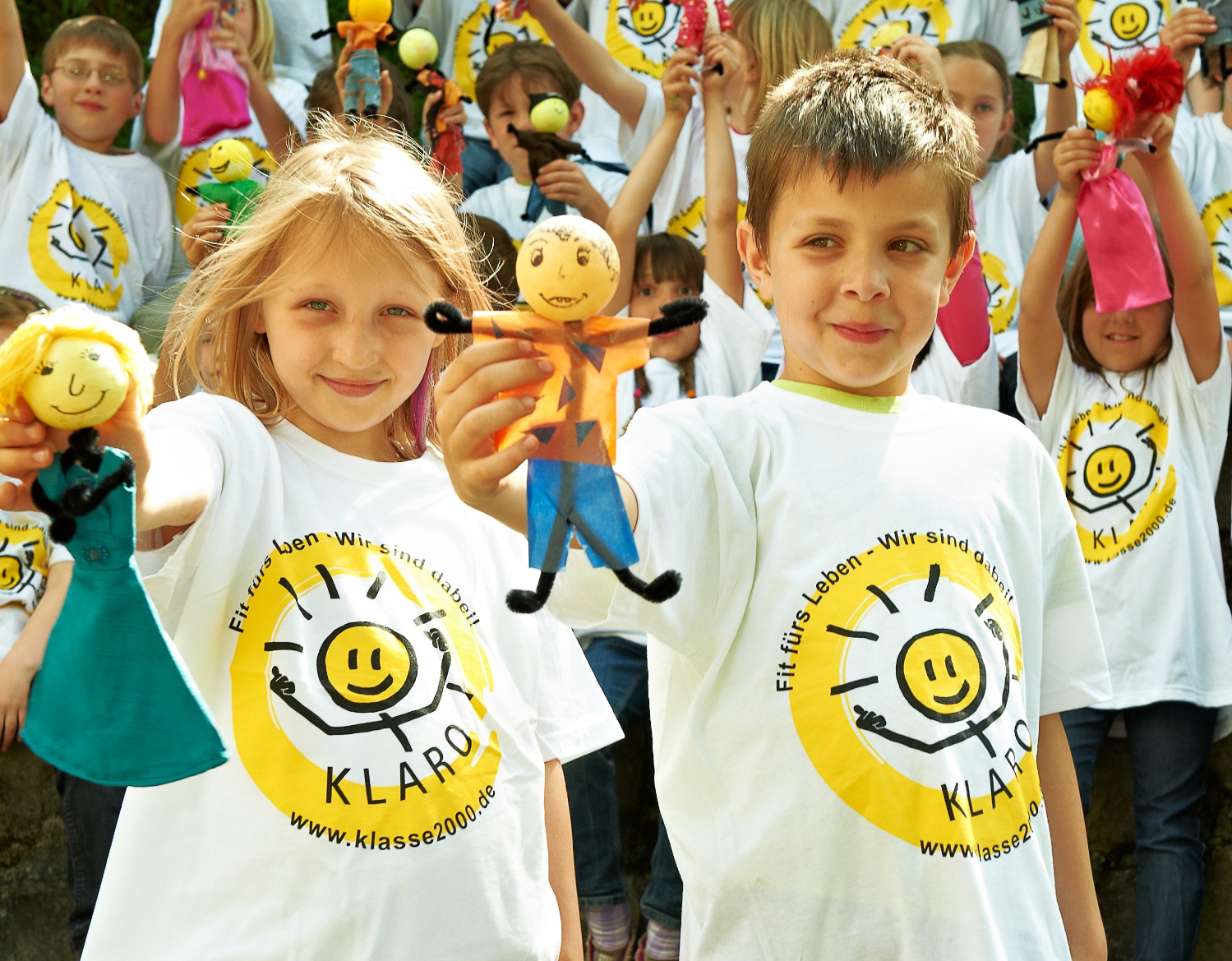 lachende Kinder - tragen das Logo "KLARO" auf dem T-Shirt